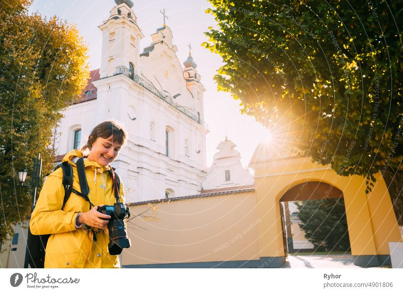 Pinsk, Region Brest, Weißrussland. Junge Frau Tourist Lady Fotografie Fotografieren in der Nähe der Kathedrale des Namens der seligen Jungfrau Maria. Berühmte historische Wahrzeichen. Sonne Sonnenschein im Herbst sonnigen Tag.