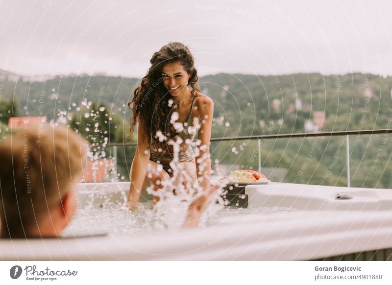 Junges Paar genießt im Freien Whirlpool im Urlaub Liebe Frau jung Glück Sommer schön Feiertage Schaumblase romantisch Wohlbefinden Wellness Mann Resort Bad