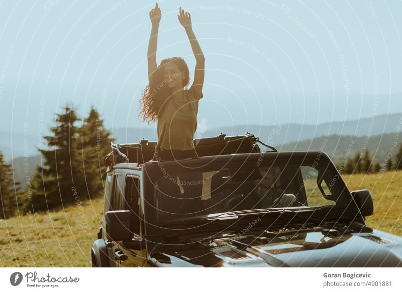 Junge Frau genießt die Freiheit im Geländewagen an einem sonnigen Tag Glück Lächeln schön Straße Laufwerk jung Fahrzeug PKW Fröhlichkeit Freude Spaß Auto