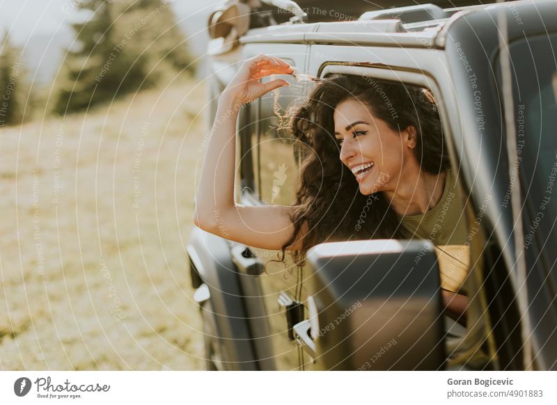 Junge Frau genießt die Freiheit im Geländewagen an einem sonnigen Tag Glück Lächeln schön Straße Laufwerk jung Fahrzeug PKW Fröhlichkeit Freude Spaß Auto