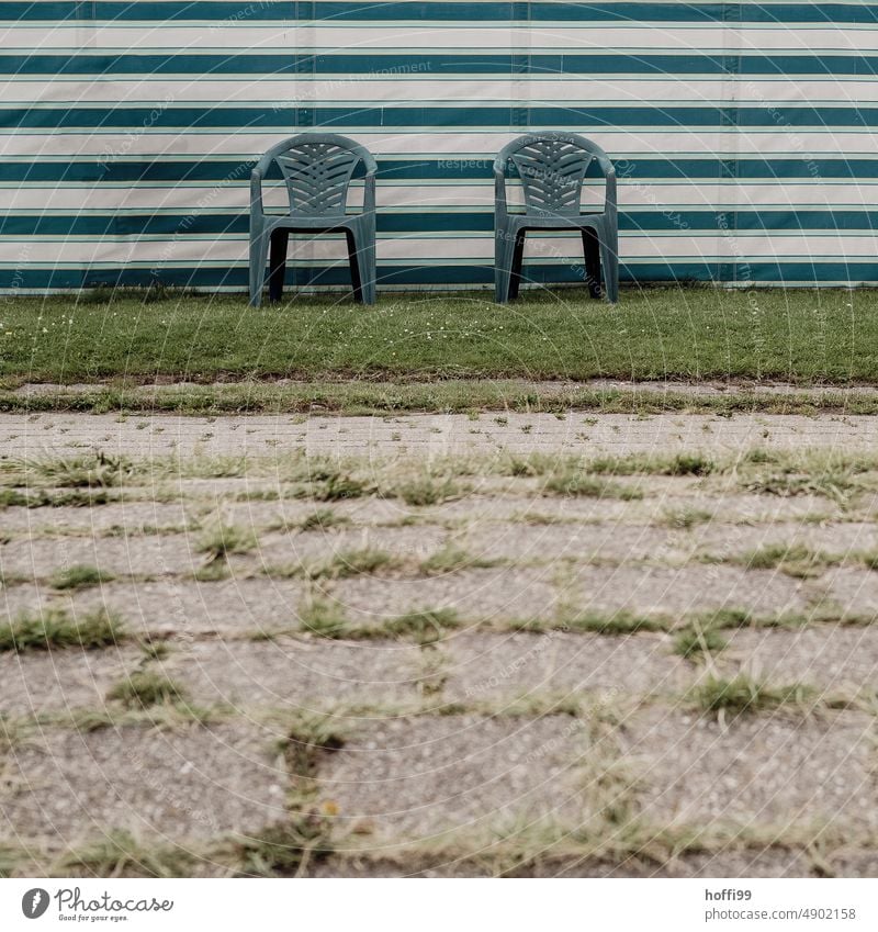 zwei blaue Plastikstühle auf einem Rasenstreifen vor einem Windschutz Plastikstuhl Campingplatz Plane Streifen Erholung Ferien & Urlaub & Reisen