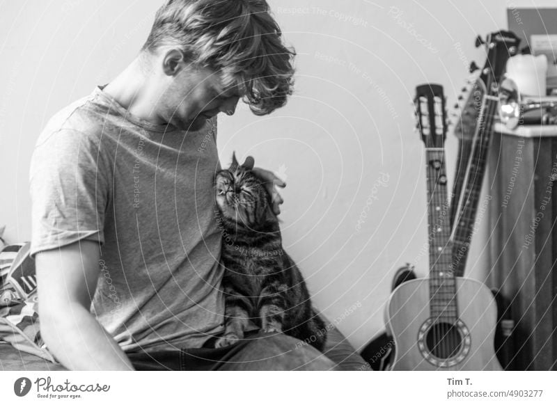 Junger Mann mit schmusender Katze Kater bnw s/w Gitarre Tag Schwarzweißfoto