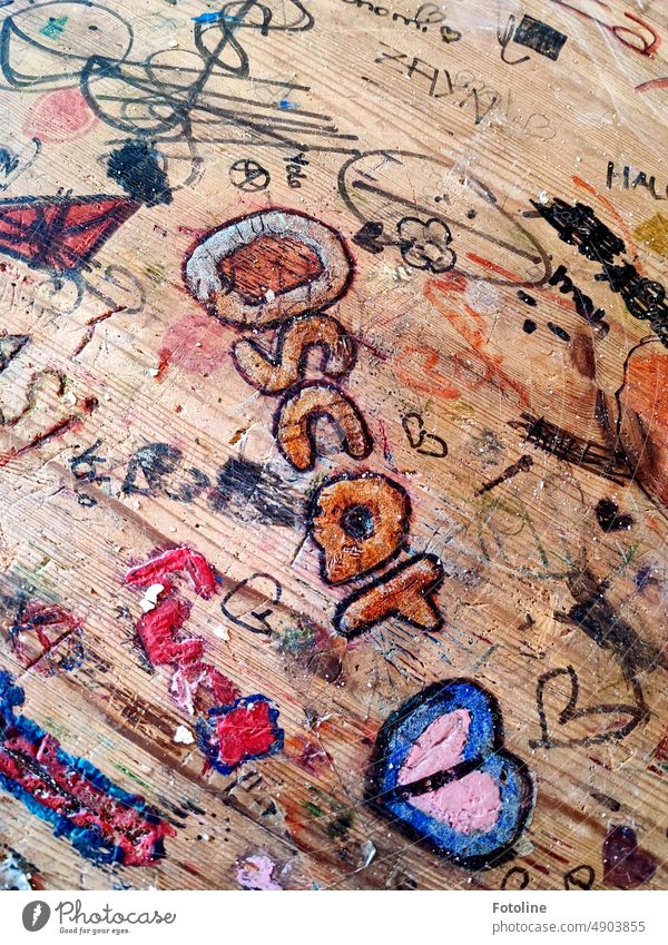 Auf einem alten Tisch in einem Lost Place irgendwo liebt jemand Oscar. Ob er es gelesen hat? Holztisch Tischplatte Holzplatte Schrift Zeichen Farbfoto braun