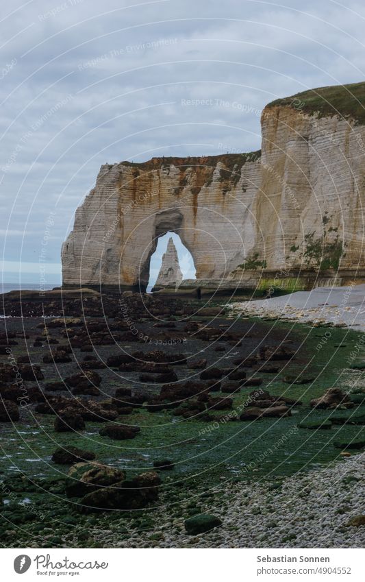 Die Nadel, gesehen durch den Bogen der Manneporte-Klippe an der Alabasterküste an einem bewölkten Sommertag, Etretat, Normandie, Frankreich Étretat Felsen Meer