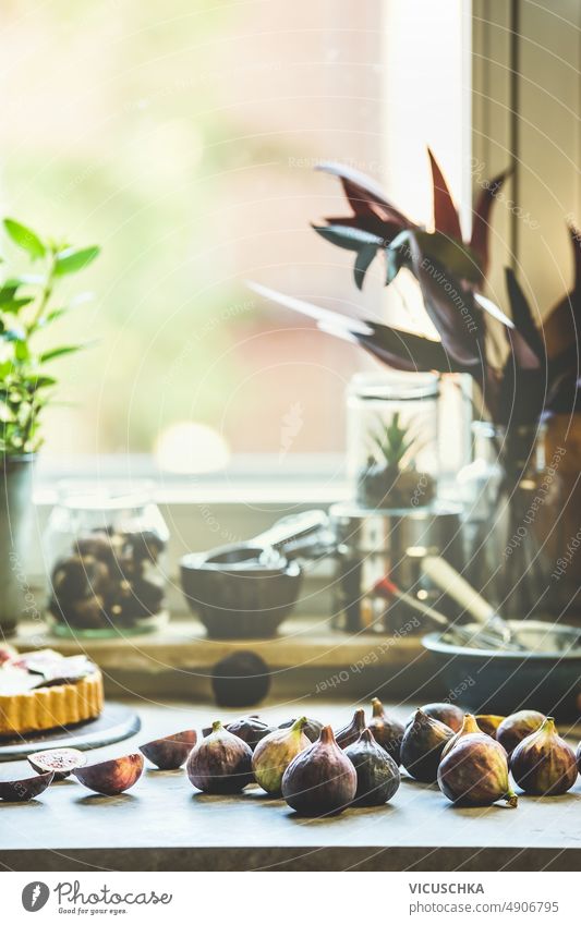 Feigen auf dem Küchentisch mit Backutensilien im Fensterhintergrund backen Utensilien Tisch Hintergrund vorbereitend mediterrane Früchte Vorderansicht