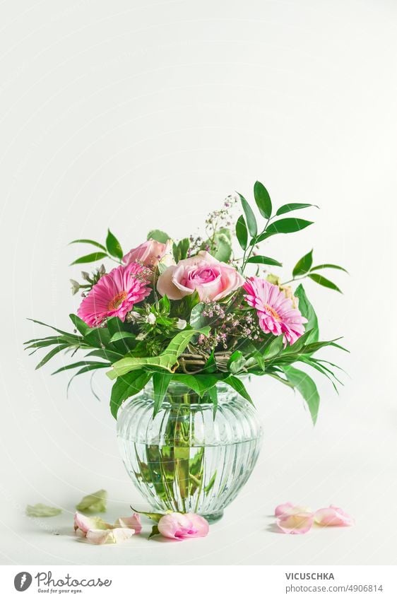 Schöne Sommerblumen Bouquet mit Rosen und Gerbera Blume und grüne Blätter in Glasvase auf weißem Hintergrund schön Blumenstrauß Vase weißer Hintergrund