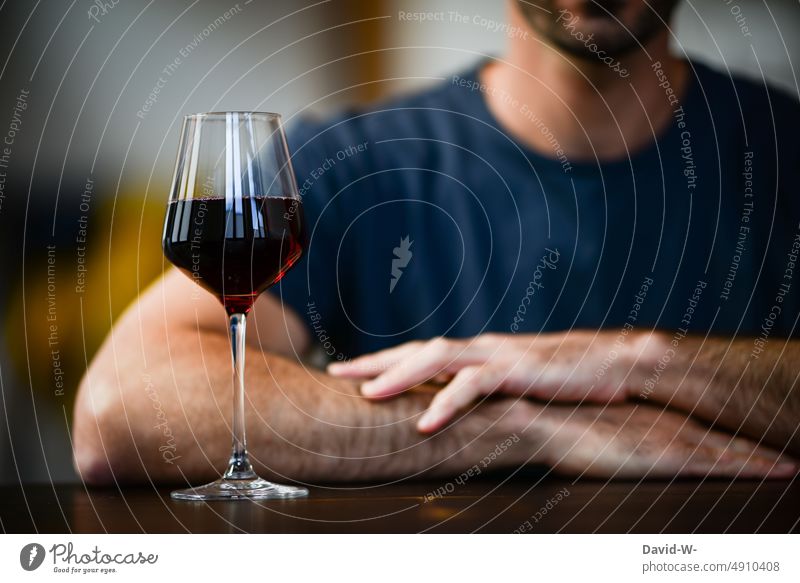 Mann sitzt bei einem Glas Rotwein am Tisch Alkohol alkoholkonsum Wein Selbstbeherrschung Getränk elegant Alkoholismus anonym