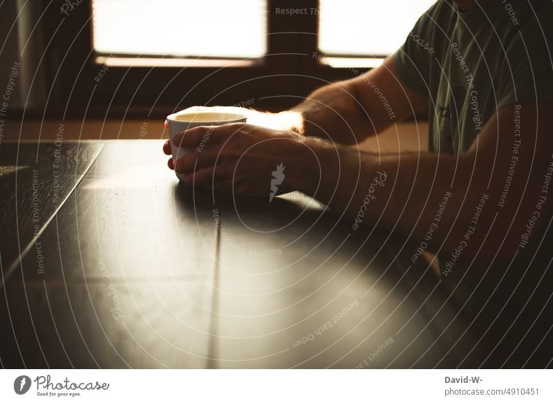 Mann mit Kaffeetasse in den Händen am Tisch im Sonnenlicht Kaffeetrinken genießen Pause Ruhe Café Erholung Auszeit Kaffeepause Heißgetränk Tasse Schatten