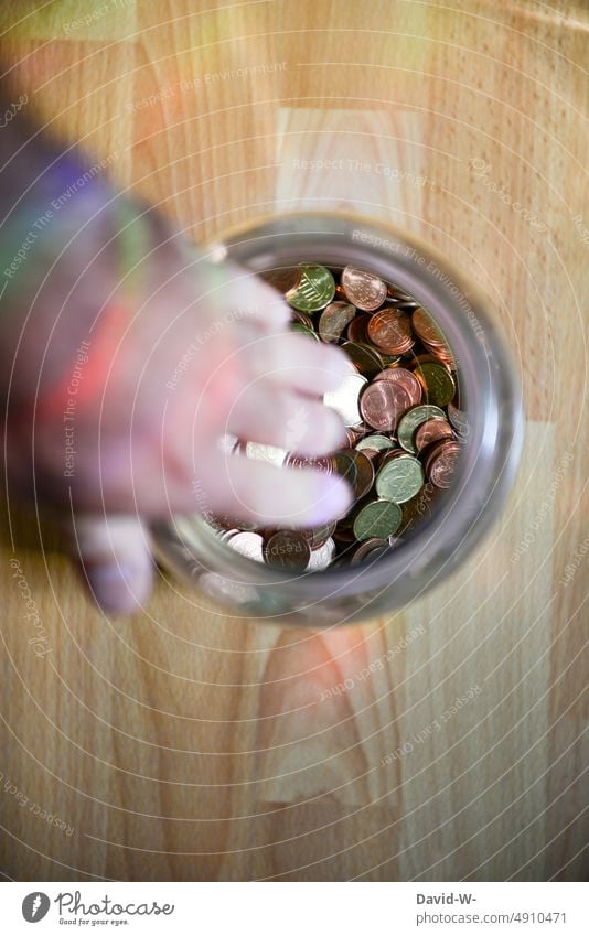 in ein Glas mit Geld greifen Geldmünzen Hand Ersparnisse Armut Rücklagen Verzweiflung pleite sparen Münzen Armutsgrenze Verzweifelung arm