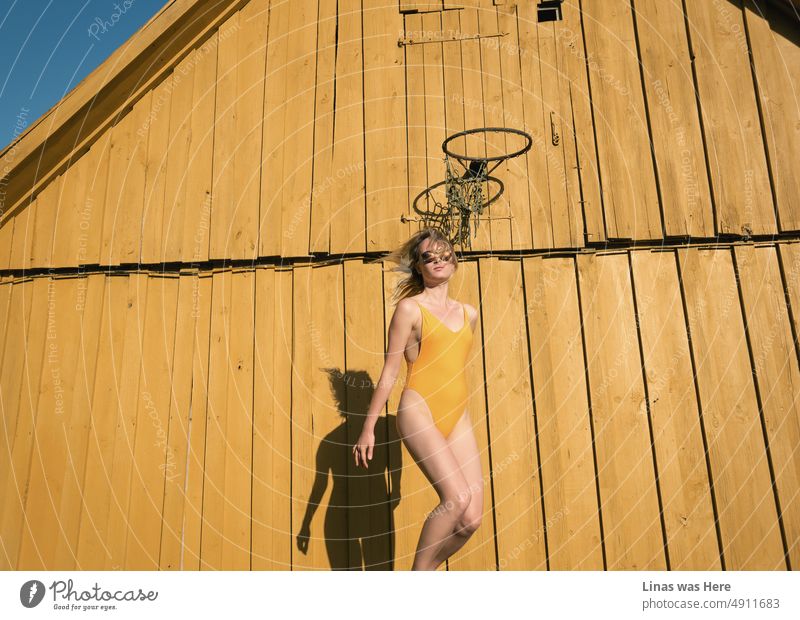 Ein wunderschönes blondes Mädchen in einem gelben Badeanzug genießt einen perfekten Sommertag auf dem Lande. Freiheit blau. Energievolles Gelb. Und alle Farben, die man braucht, um das ukrainische Volk jetzt zu unterstützen. Slava Ukraini, Heroyam Slava!