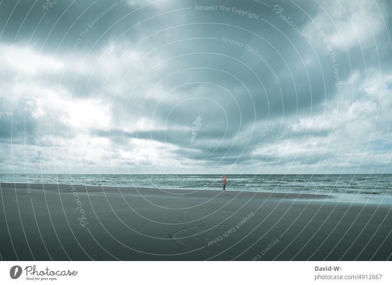 Mann steht in der Ferne am Strand und beobachtet die raue See Meer Sturm Wellen Nordisch Küste Ostsee Nordsee Beobachten Ferien & Urlaub & Reisen Wasser Ruhe