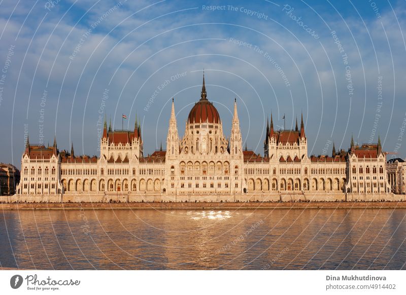 Ungarisches Parlamentsgebäude in Budapest, das sich im Wasser der Donau spiegelt, fotografiert an einem sonnigen Tag mit blauem Himmel. Gewölbte Architektur im neugotischen Stil. Berühmtes Wahrzeichen für Sightseeing in Ungarn. Postkartenansicht.