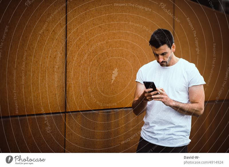 Mann benutzt ein Smartphone Handy benutzen lesen Hände tippen Nachricht Mitteilung SMS Alltagsfotografie