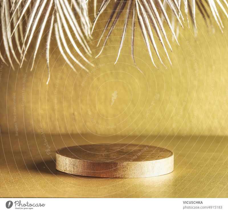 Goldenes modernes Produktdisplay mit Podium und silbernen Palmenblättern. Luxuriöse Kulisse golden Produktpräsentation Silber Reichtum Hintergrund Szenenaufbau