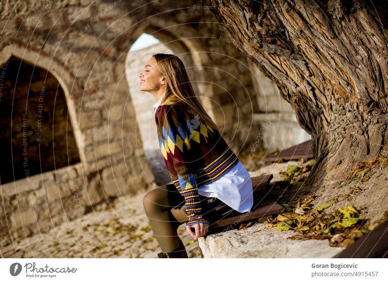 Junge Frau sitzt auf der Bank beobachten gelbe Blätter Baum im Herbst Park Natur Mädchen Person jung sich[Akk] entspannen Lifestyle im Freien Schönheit schön