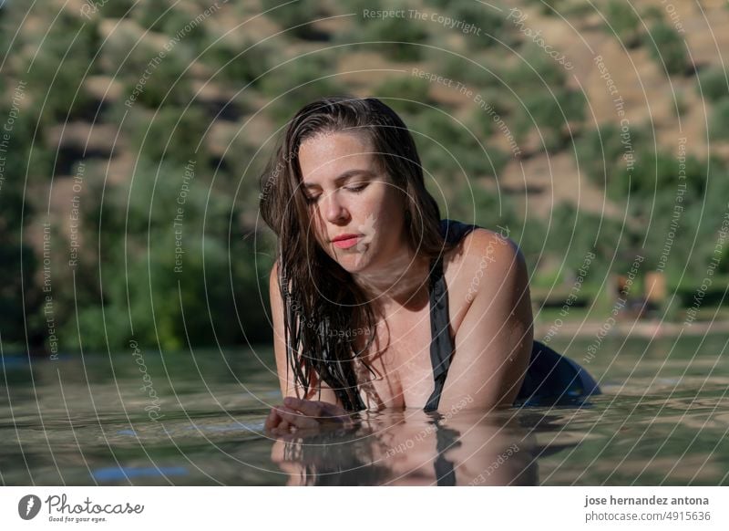 attraktives junges lateinamerikanisches Mädchen am Ufer eines Sees liegend sexy Wasser Frau schwimmen hübsch Lügen Körper Badebekleidung Model Sonnenlicht