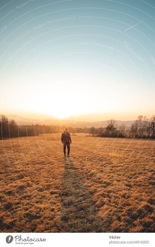 Junger ehrgeiziger Tourist geht bei Sonnenuntergang durch die Getreidefelder in den Beskiden, Tschechische Republik. Er besinnt sich auf sich selbst. Ein Spaziergang an der frischen Luft