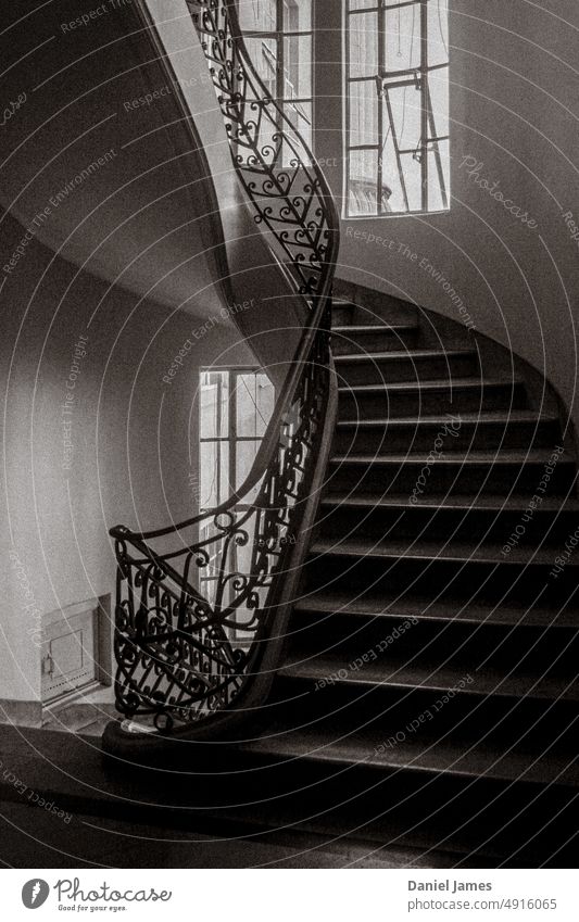 Geschwungene altmodische Treppe mit originellem Geländer Treppenhaus Erbe altehrwürdig klassisch historisch Schwarzweißfoto Korn Kurve Fenster stylisch