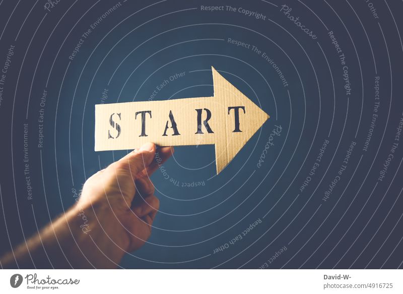 Start - Pfeil in der Hand Anfang Konzept richtungweisend Beginn anfangen Richtung vorwärts Ziel Zukunft Wegweiser