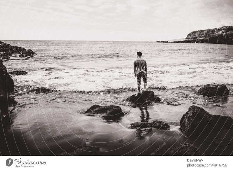 Mann schaut aufs Meer hinaus Ozean Aussicht Ruhe beobachten Wellen Erinnerung Urlaub Strand Küste Freiheit Ferne Wasser