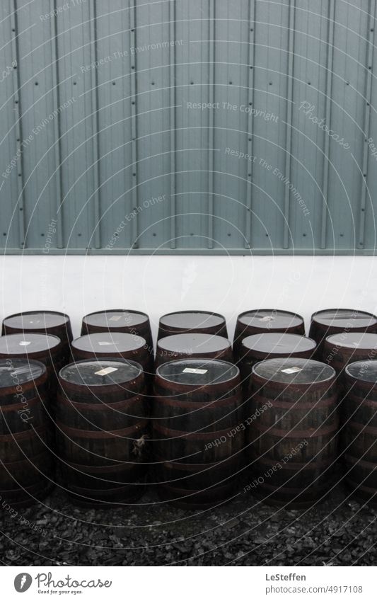 Whiskyfässer stehen vor einer schottischen Destille nach dem Regen. Fässer Fass destillerie Schottland Wasserspiegelung minimalistisch modern kalt Symetrie