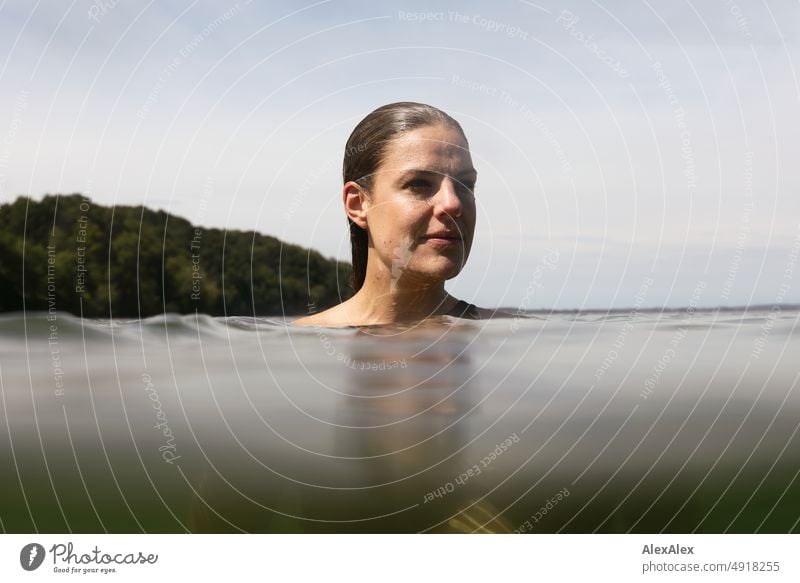 Junge, schöne Frau im flachen Wasser in der Ostsee schaut zur Seite Lifestyle Gegenlicht gesund sportlich schlank ästhetisch jugendlich anmutig selbstbewußt