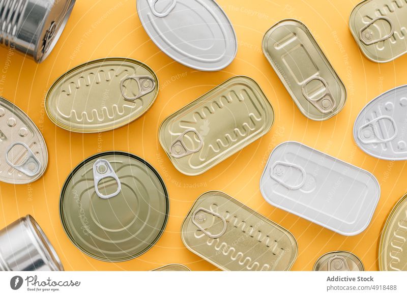 Reihe von Dosen auf gelbem Hintergrund Büchse Metall Blechdose Lebensmittel Container konserviert vereinzelt Produkt Verpackung Leichtmetall konservieren blanko