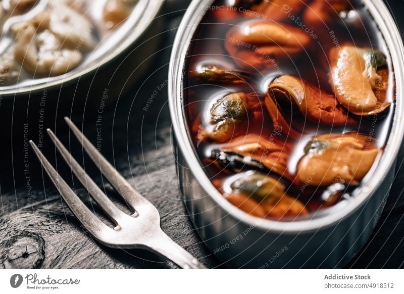 Dosen mit Konserven auf einem Holzhintergrund Dosennahrung Metall Blechdose Octopus Sardinen Sardellenfilets Lebensmittel Container beruhigt konserviert