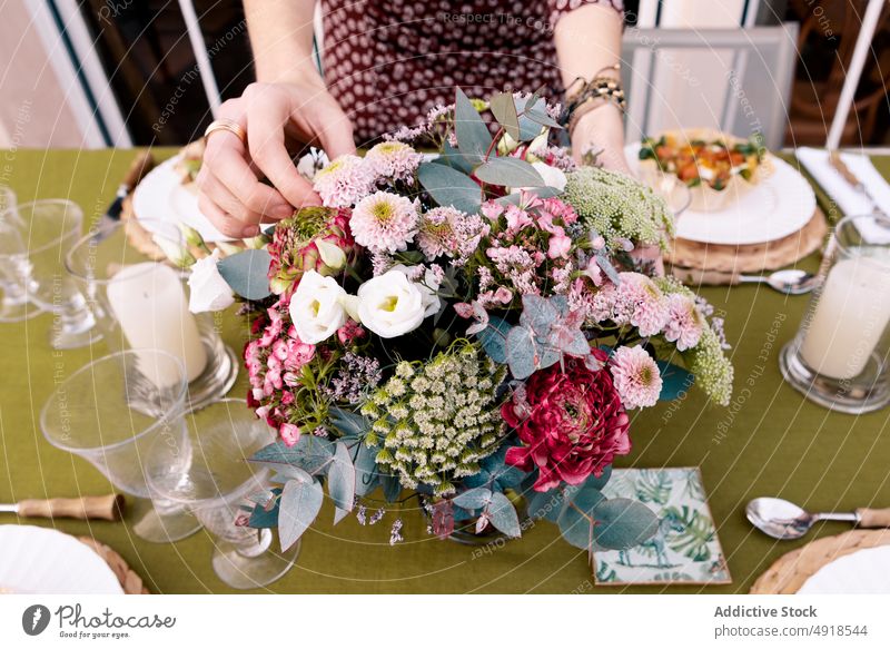 Anonyme Frau, die auf der Terrasse einen Tisch zusammenstellt einrichten Lebensmittel Blume Amuse-Gueule Festessen Zeit verbringen freie Zeit geschmackvoll