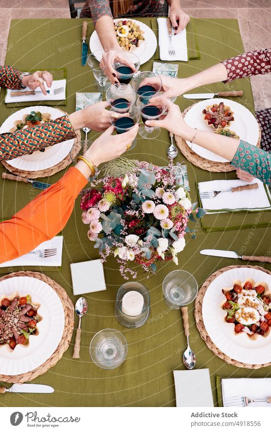 Frauen stoßen auf der Terrasse mit Weingläsern an Klirren Weinglas Freund Zuprosten jubelt feiern trinken Sitzung Wiedersehen Unternehmen Salatbeilage