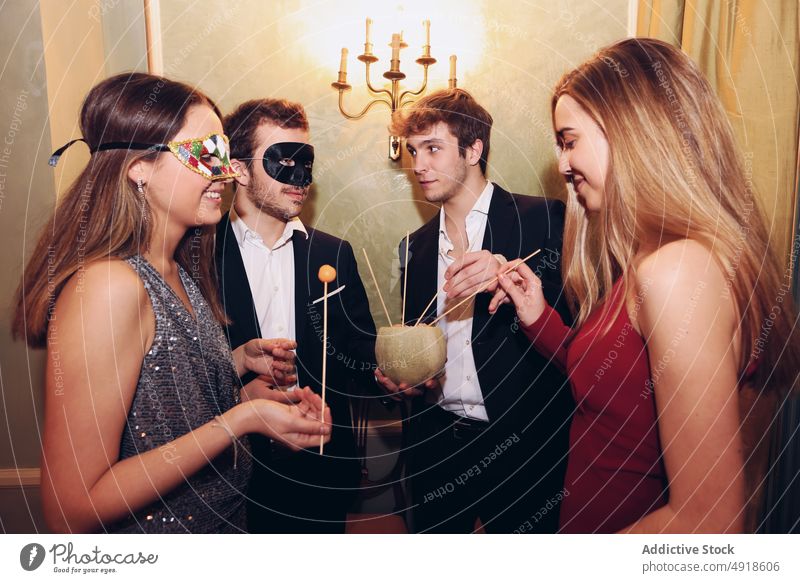 Menschen in Maskerade-Masken essen Melone während einer Party Freund Menschengruppe Melonen Frucht Ball Mundschutz feiern Anlass Lebensmittel Restaurant