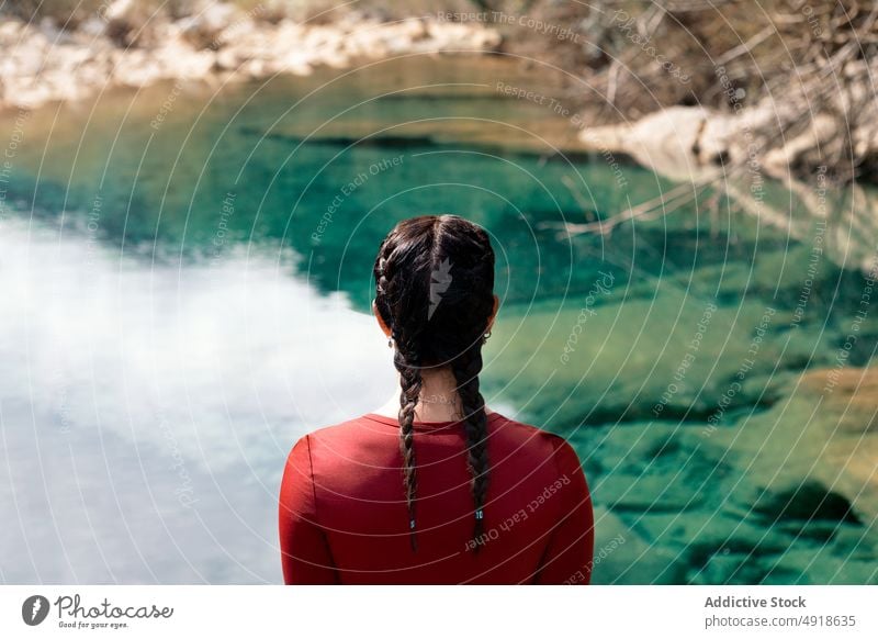 Rückenansicht Frau mit Zöpfen schaut auf den Fluss Wald Rückansicht Urlaub Lifestyle anonym Natur reisen jung Steine im Freien Menschen Freizeit Aktivität