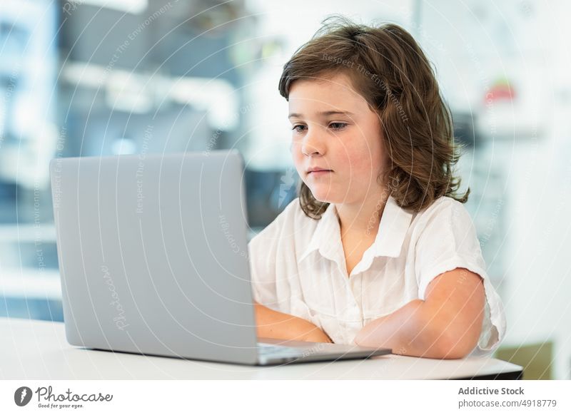 Mädchen vor einem Laptop sitzend jung heimwärts Computer Schüler Bildung Kopfhörer Lernen Fokus schön Browsen studierend online Internet Person ernst