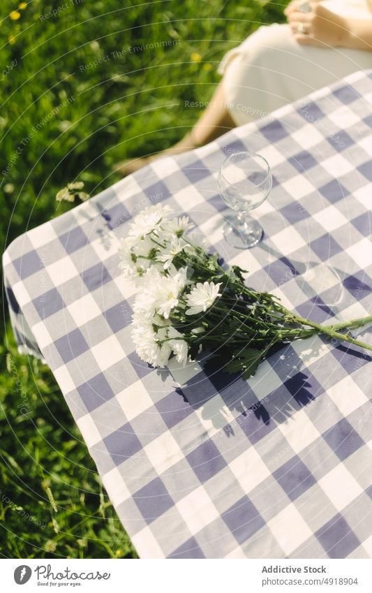 Unbekannte Frau sitzt auf einem Tisch mit Blumen Feld Landschaft Blumenstrauß sitzen Natur Zeitvertreib Erholung feminin Sommer Dame ländlich Flora