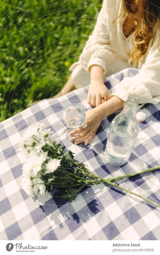 Unbekannte Frau trinkt Wasser aus einem Becher auf einem Feld Glas Tisch Kelch Erfrischung Getränk Landschaft Natur Zeitvertreib Erholung trinken feminin Sommer