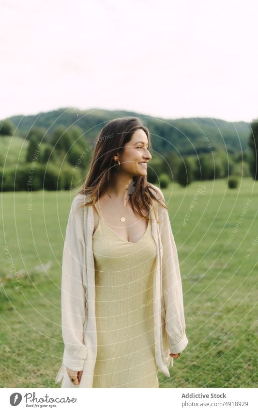 Junge lächelnde Frau auf einem Feld im Sommer Landschaft Freude Wiese Gras Kleid froh Natur Zeitvertreib heiter Lächeln feminin Waldgebiet ländlich Flora