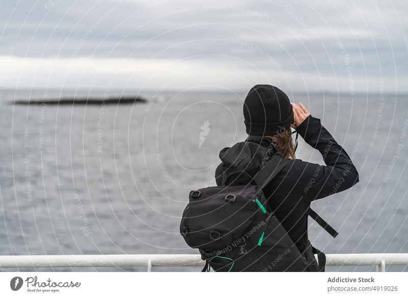 Fotografin auf dem Schiffsdeck Frau fotografieren MEER Küste Wasser Gedächtnis reisen Island Mantel Hut Rucksack Boot Oberbekleidung schießen dumpf Fotografie