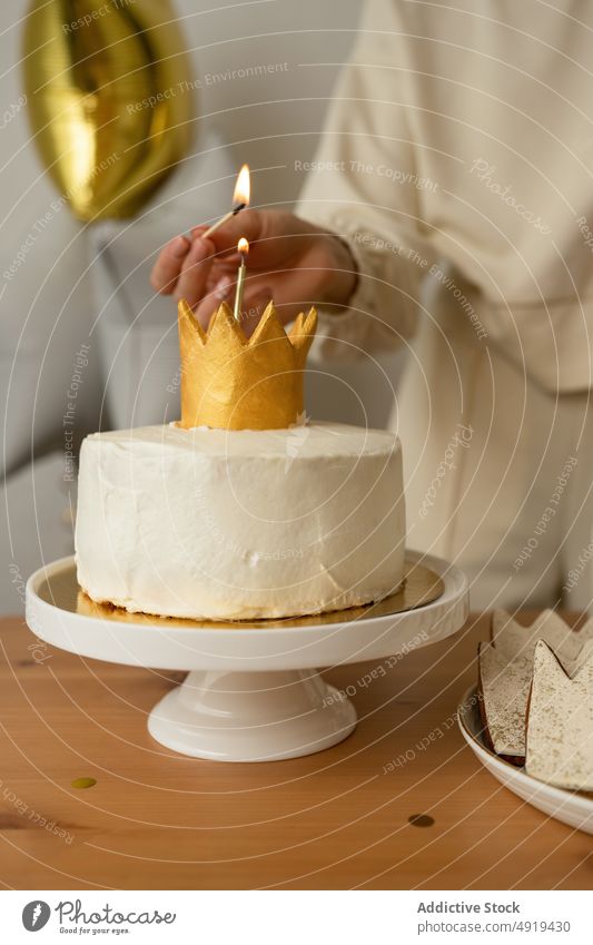 Unbekannte Frau zündet eine Kerze aus einem Muffin an Cupcake Kuchen anonym süß Mädchen Sahne Lebensmittel lecker Dessert gesichtslos Ernte Person Hintergrund