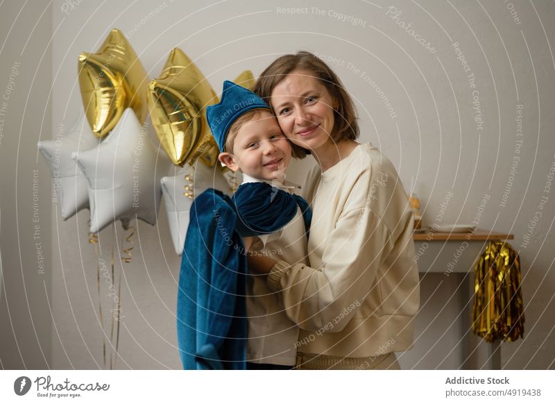 Mutter hält kleinen Jungen mit blauer Mütze in der Hand Kind Party Geburtstag Glück Spaß Sohn Lächeln Feiertag niedlich Ballons Stern Kindheit küssen Kap