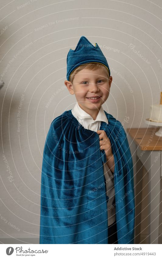 Junge mit blauem Umhang, der sich auf einer Party amüsiert Kind Geburtstag Krone Glück Spaß Feiertag niedlich Kindheit Menschen Kap Hintergrund heiter