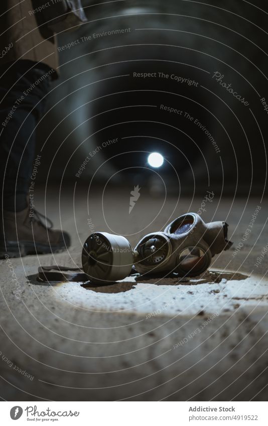 Gasmaske auf dem Boden im Tunnel Entdecker Stollen Apokalypse Grunge behüten Atemschutzgerät verschmutzen halbdunkel Sicherheit Gerät Verlassen rau Gefahr