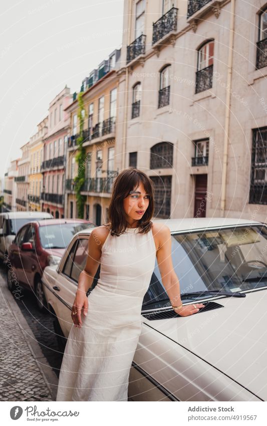 Frau in der Nähe eines Retro-Autos in der Stadt Straße PKW Großstadt Stil Oldtimer retro altehrwürdig Kleid geparkt Gebäude Kleidung Optimist schäbig verwittert