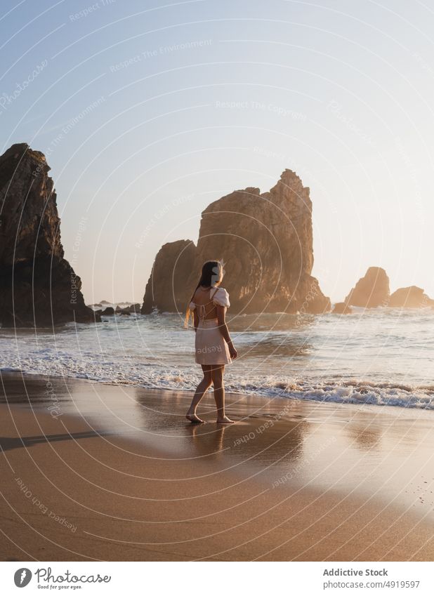 Frau geht am Ufer mit Klippen spazieren Reisender Spaziergang MEER Felsen Strand Wasser Sonnenuntergang Sonnenlicht Tourist Abend Zeitvertreib Freizeit