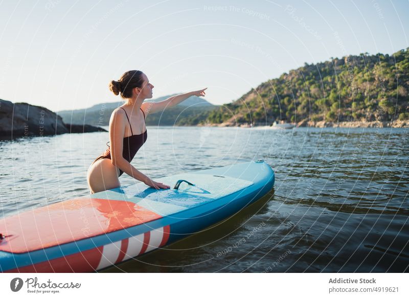 Frau im See stehend mit Surfbrett Surfer Freizeit Hobby Zeigen Wasser Natur Wohlbefinden Ausflug Sommer Seeküste Zusatzplatine Paddelbrett Ufer Küste Wälder