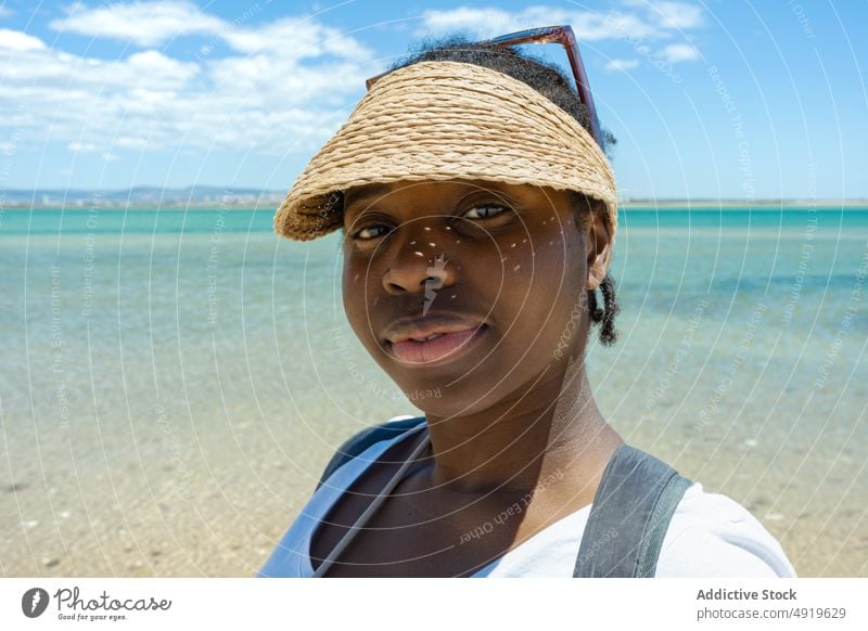Porträt ernsthafte schwarze Frau am Strand und Blick in die Kamera MEER Meeresufer Sommer Mädchen in die Kamera schauen Sand schön jung Lifestyle reisen Urlaub