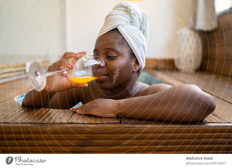 Schwarze Frau trinkt einen Saft in einem Whirlpool Spa schwarz jung Jacuzzi Schönheit sich[Akk] entspannen trinken Lifestyle Erholung Glück attraktiv Reichtum