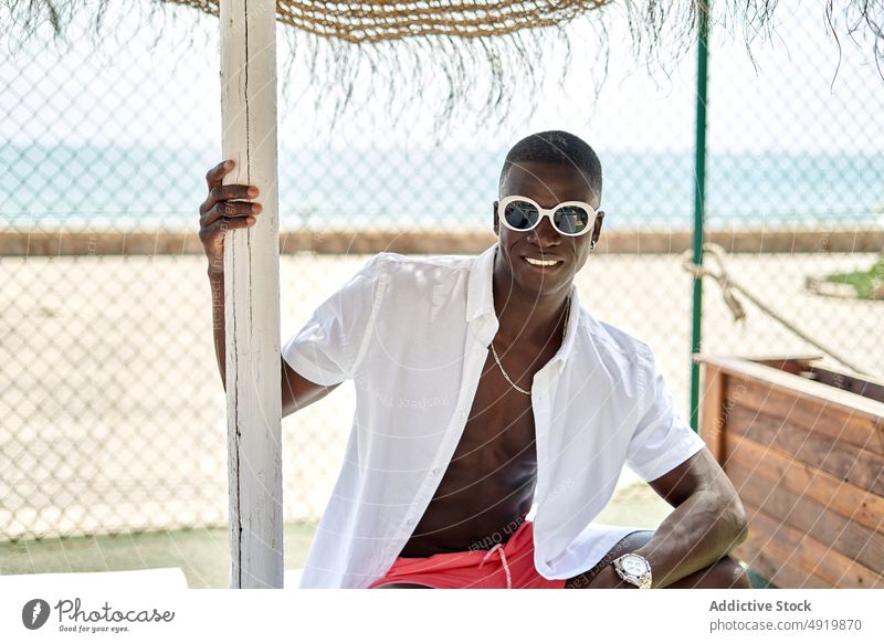 Schwarzer Mann auf Stuhl ruhend Erholung sich[Akk] entspannen Kälte Zeitvertreib Sonnenbrille schwarz Afroamerikaner ethnisch Liege Sommer selbstbewusst trendy