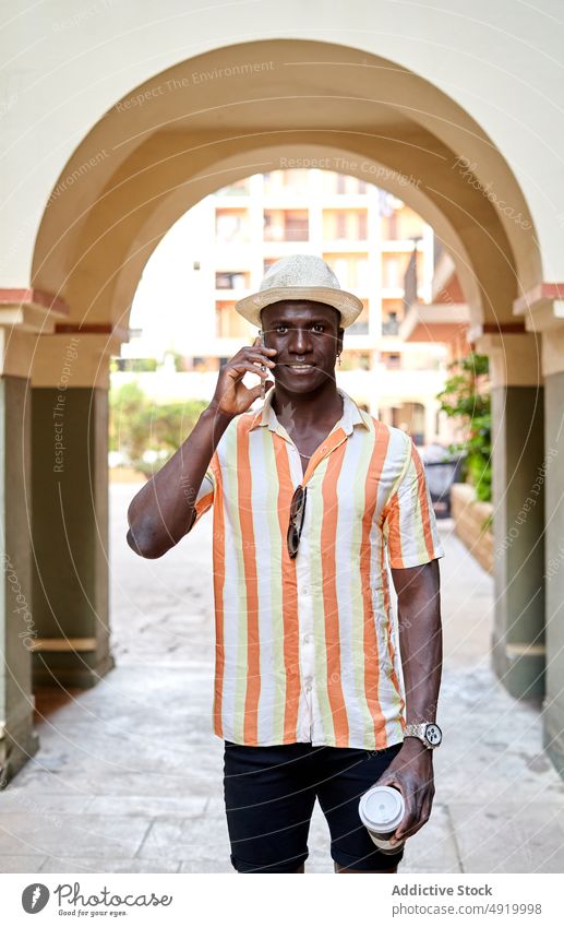 Schwarzer Mann führt Telefonat auf der Straße Smartphone Telefonanruf Großstadt Bogen Talkrunde Kommunizieren reden urban schwarz Afroamerikaner ethnisch
