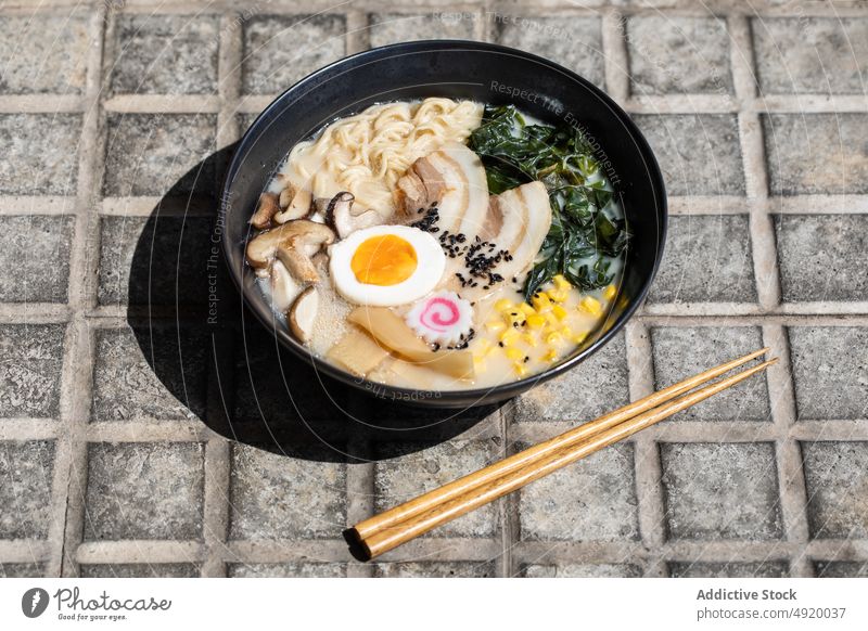 Leckere Ramen auf dem Bürgersteig serviert Japanisch Nudel traditionell Pilz Kultur Speise Straßenbelag Straßenessen Ei Bestandteil Brühe Laufsteg Sonnenlicht