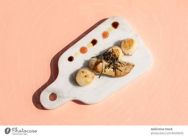 Jakobsmuscheln mit Gänsestopfleber auf Marmorschneidebrett Meeresfrüchte Gänseleber Speise Küche Murmel Schneidebrett Delikatesse anspruchsvoll Haute Cuisine